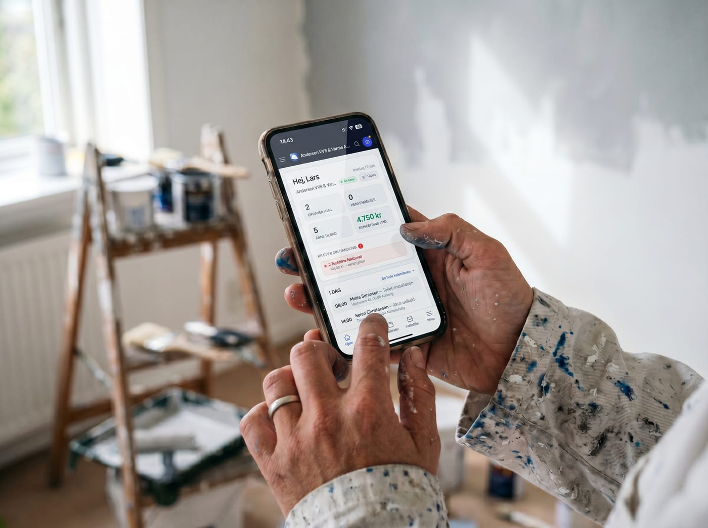 Hands holding a phone with Online Erhverv open on the painting job