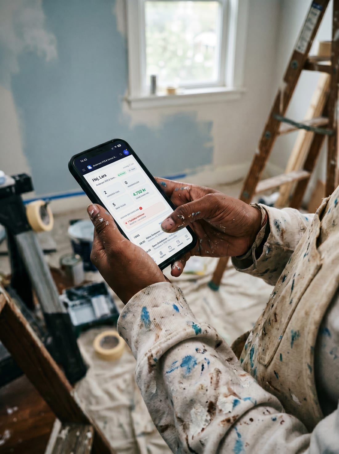 A painter using Online Erhverv on the phone in the middle of a job